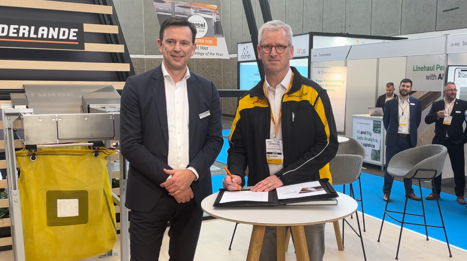 L-R: Patrick Verhoeven, Vanderlande’s executive managing director APS EMEA LATAM, and Dietmar Doll, VP engineering with DHL Group, sign the contract at Parcel+Post Expo 2024